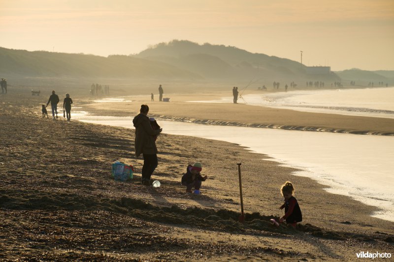 Strandactiviteit bij zonsondergang