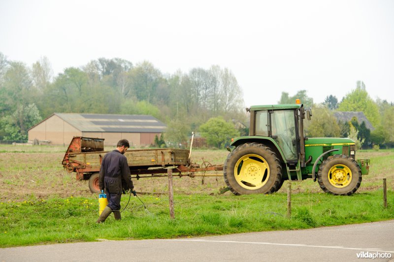 Boer spuit gif langs een wegberm